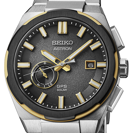 Relógio Seiko Astron GPS Solar SSJ026J1: detalhes do mostrador cinzento-escuro com textura de grãos de areia e apontamentos de dourado.
